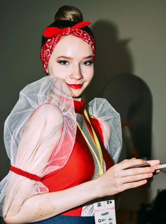 a woman is wearing a veil and holding a small pair of scissors