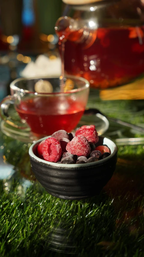 berries and tea sit on top of the grass