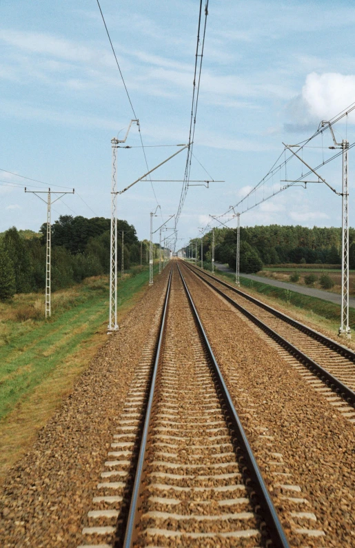 two train tracks going in opposite directions across a field