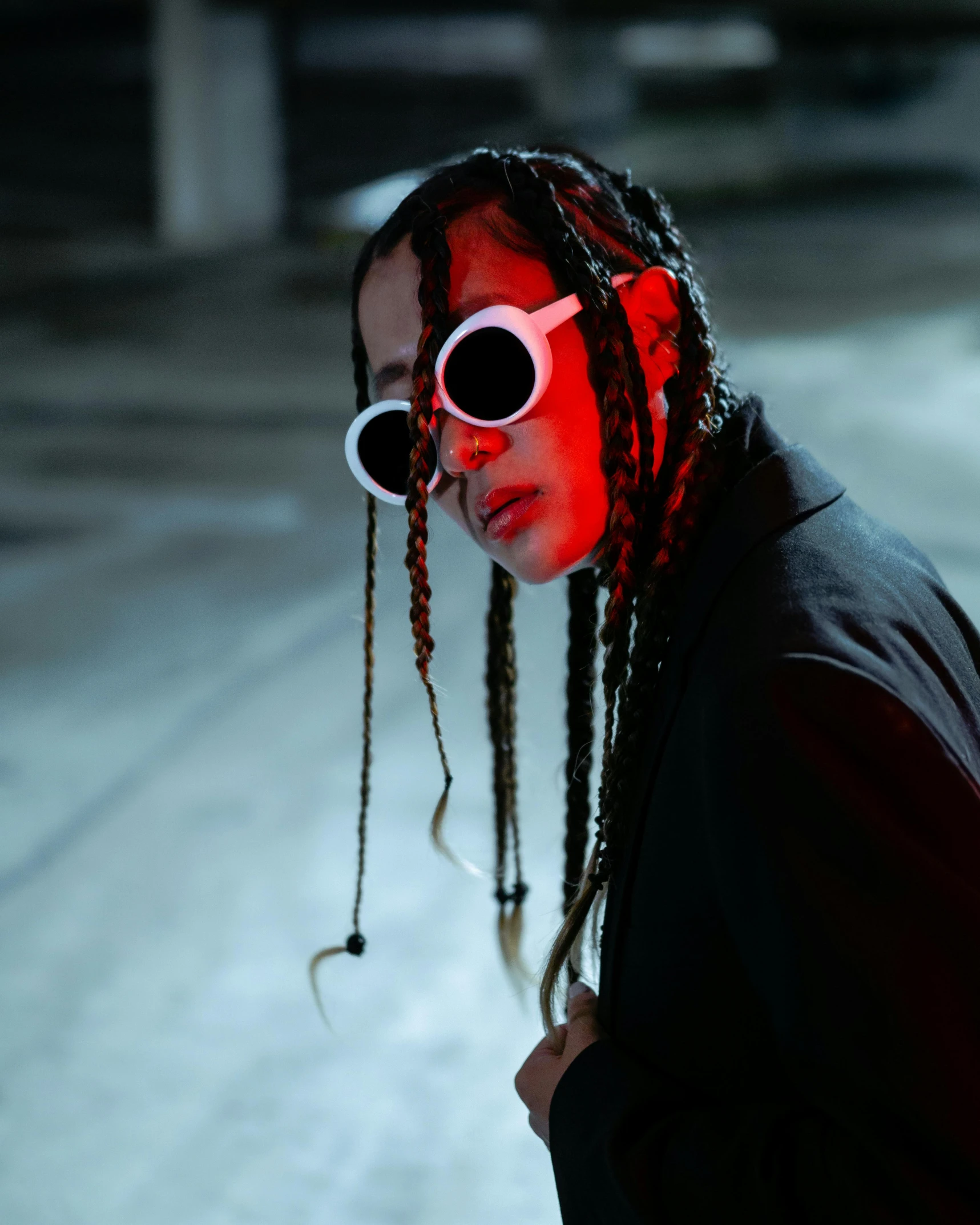 young person with red light sunglasses, a pair of black lenses