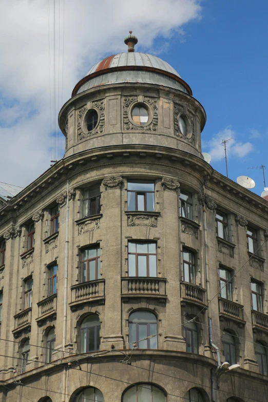 an old grey building has round windows and a clock tower