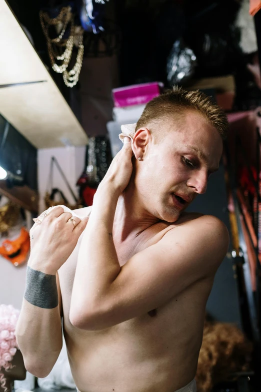 a man with a tattoo trying to fix his ears