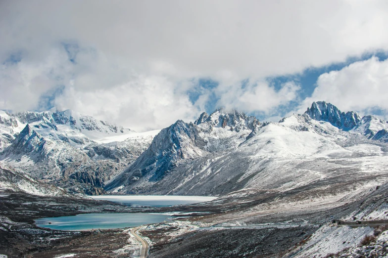 a large mountain range in the middle of a snowy field