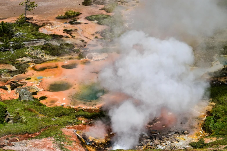 steam rises from a fisaping in a natural landscape