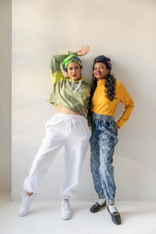 two girls posing with a wall and a green wig