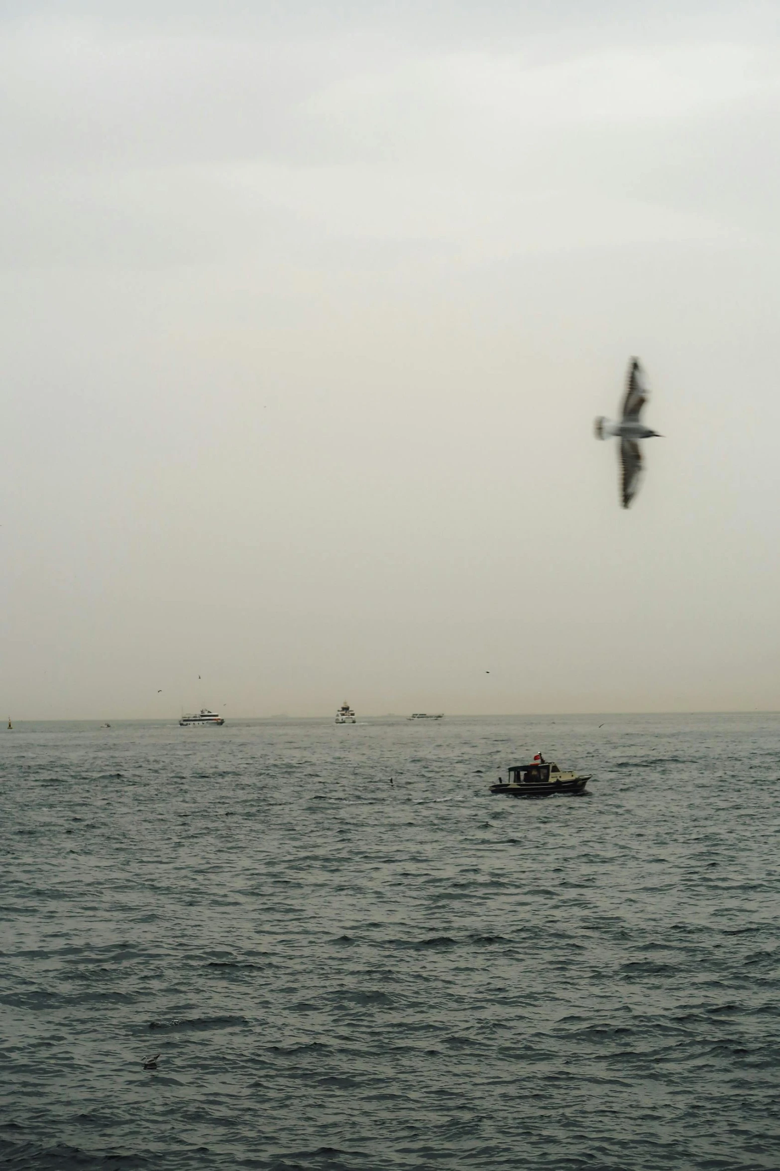 a plane flying above the ocean next to boats