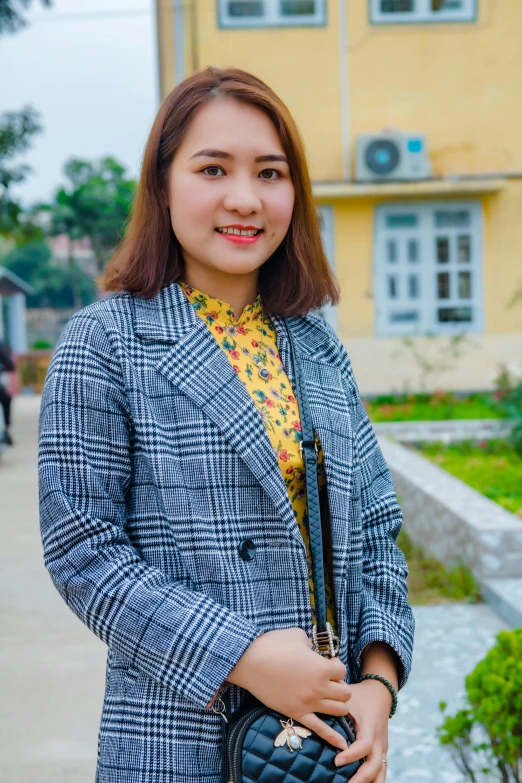 a beautiful young woman holding a black purse