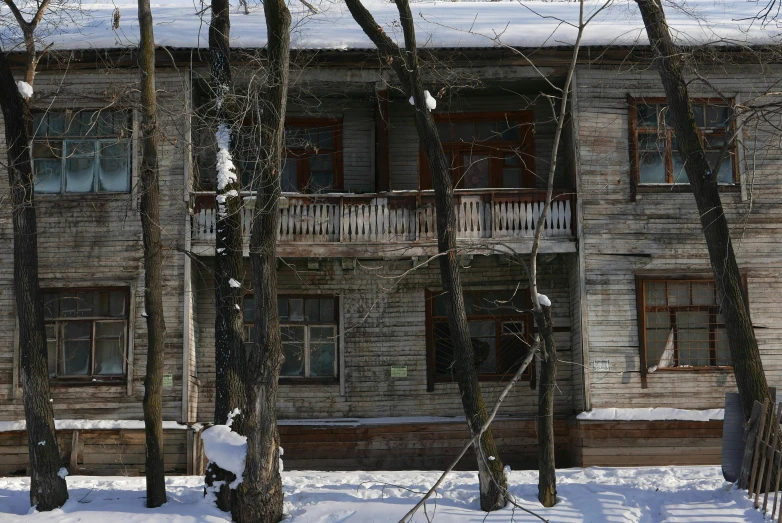 a snowy area next to the building with a fence and snow covered ground