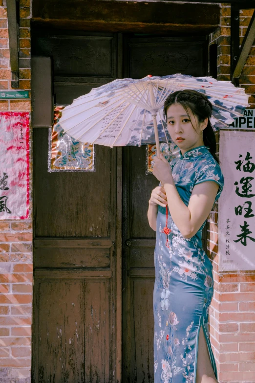 the woman is standing in front of the doors holding an umbrella