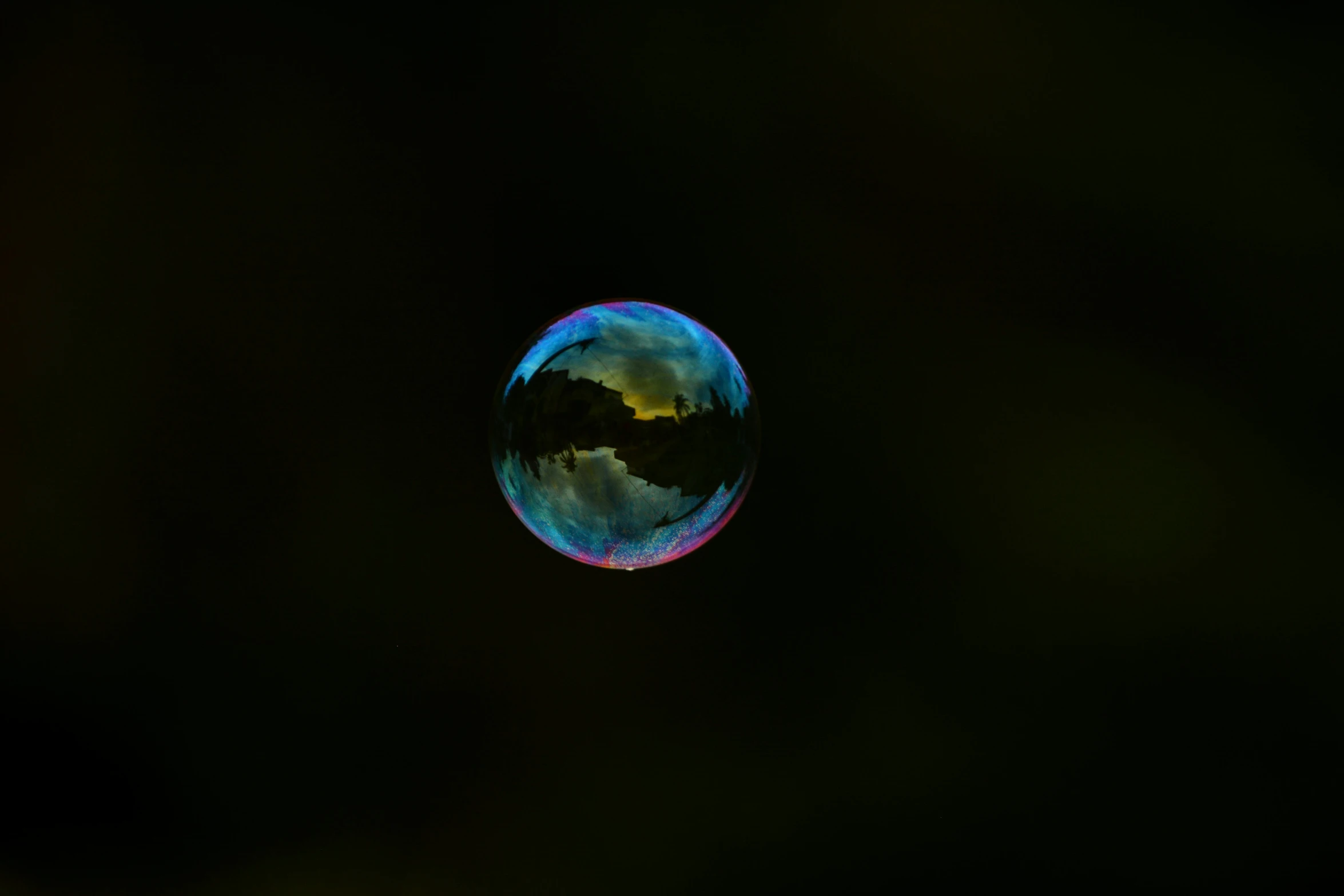 a po taken from below of a glass orb with clouds in the background