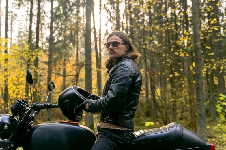 a man in black jacket riding a motorcycle