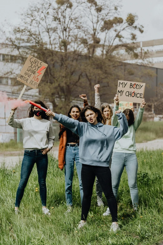 several girls holding up signs with the words my body is your choice