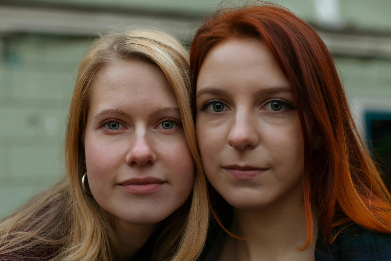 two beautiful women standing side by side next to each other