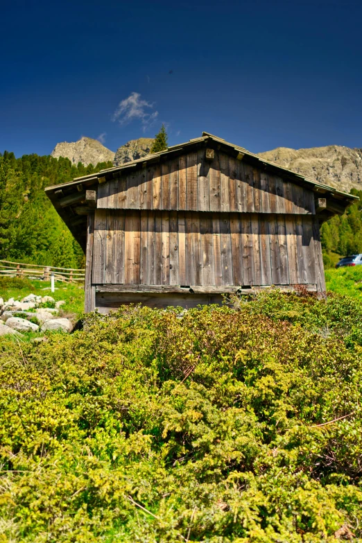 the old barn sits beside the mountains in the daytime