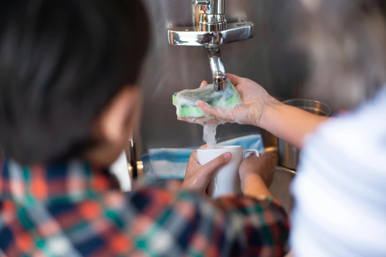 woman is cleaning her hands with soap and a sponge