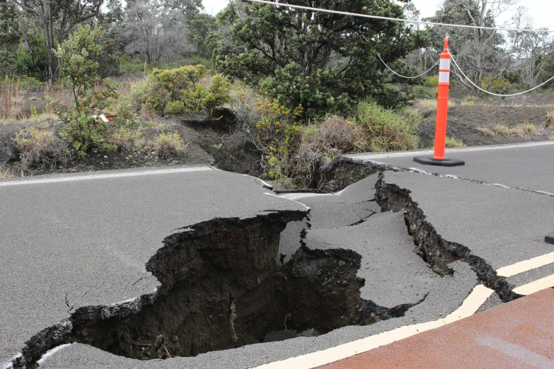 a sink hole in the road with a sign attached to it