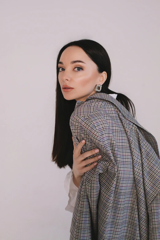 a woman with her jacket up holding her jacket