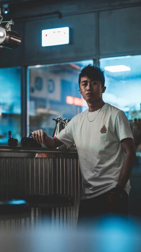 a young man in a white shirt at the bar