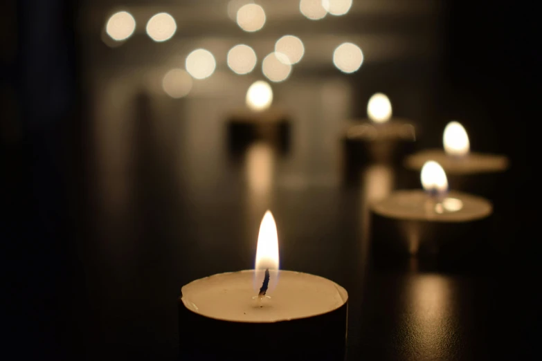 lit candles sitting on a table, lit up with one candle