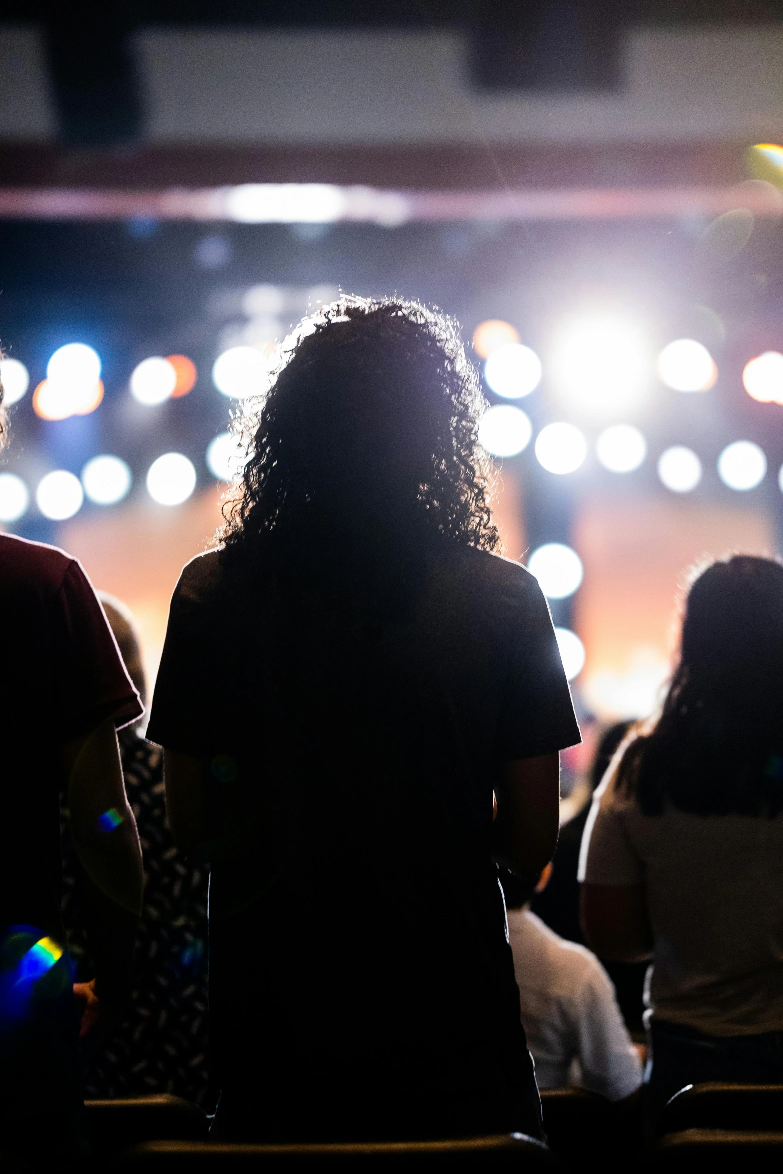 several people in a dark area with bright lights