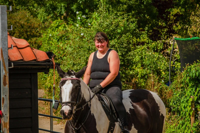 the woman is riding her horse along the dirt path