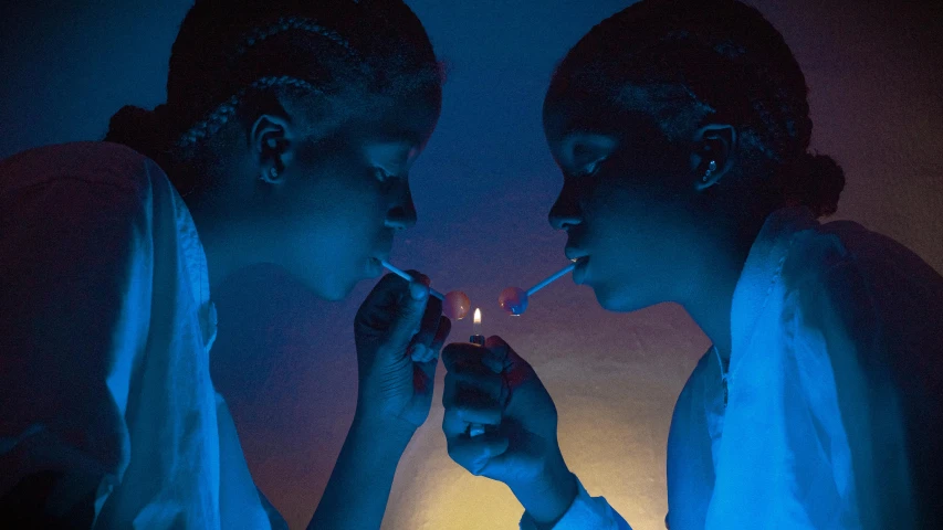 two people in a dark room lights and smoke