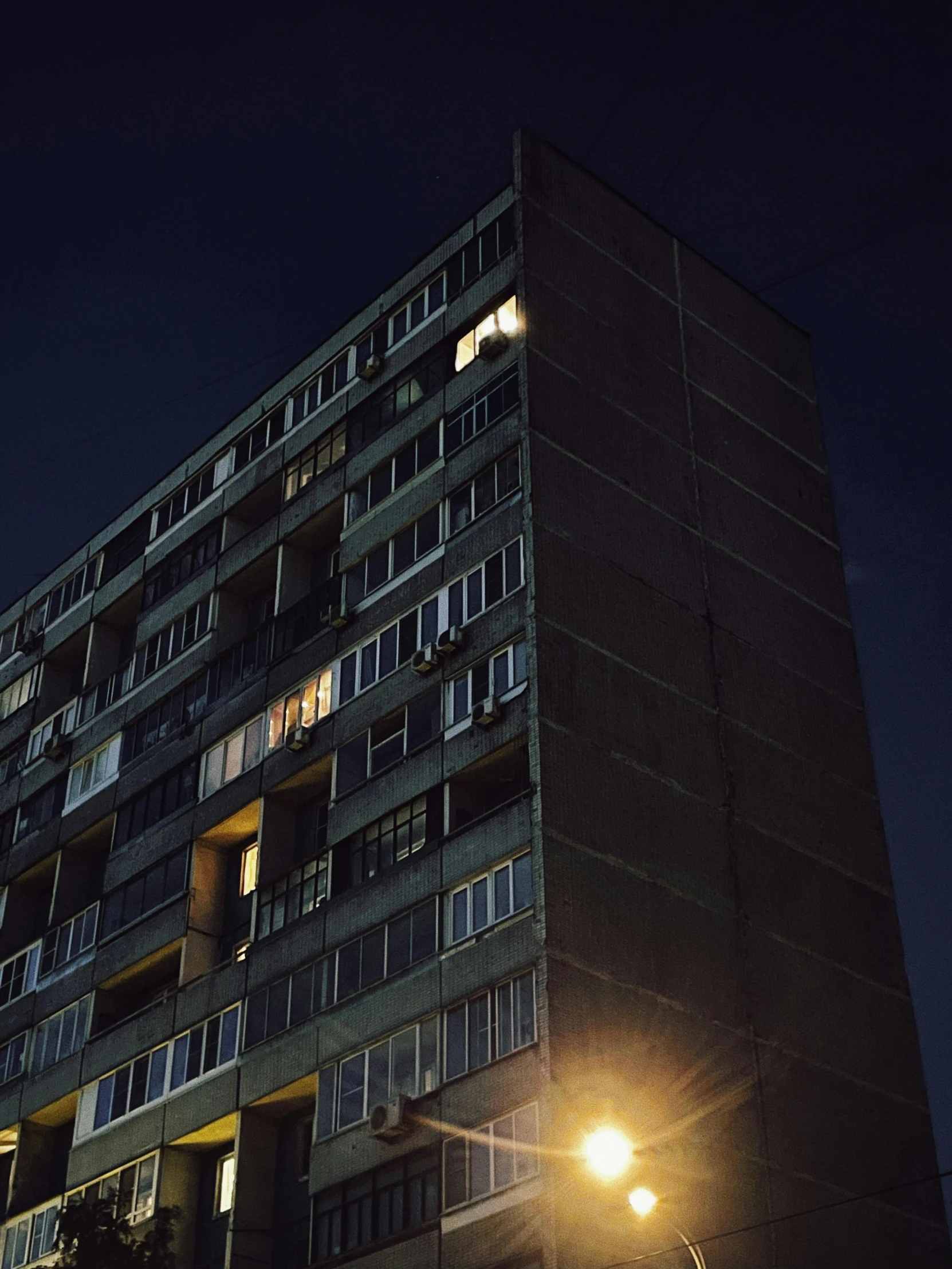 a tall building at night with windows lit up