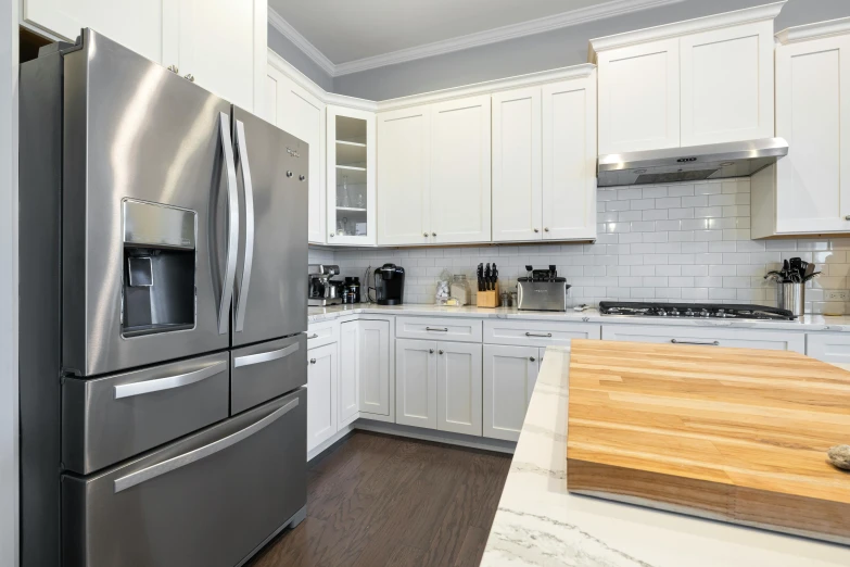 white kitchen cabinets with stainless steel appliances and wood counter tops