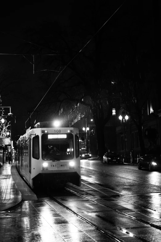 a trolley car is driving along a rainy city street