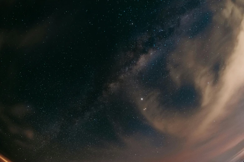 a night sky filled with stars and some clouds