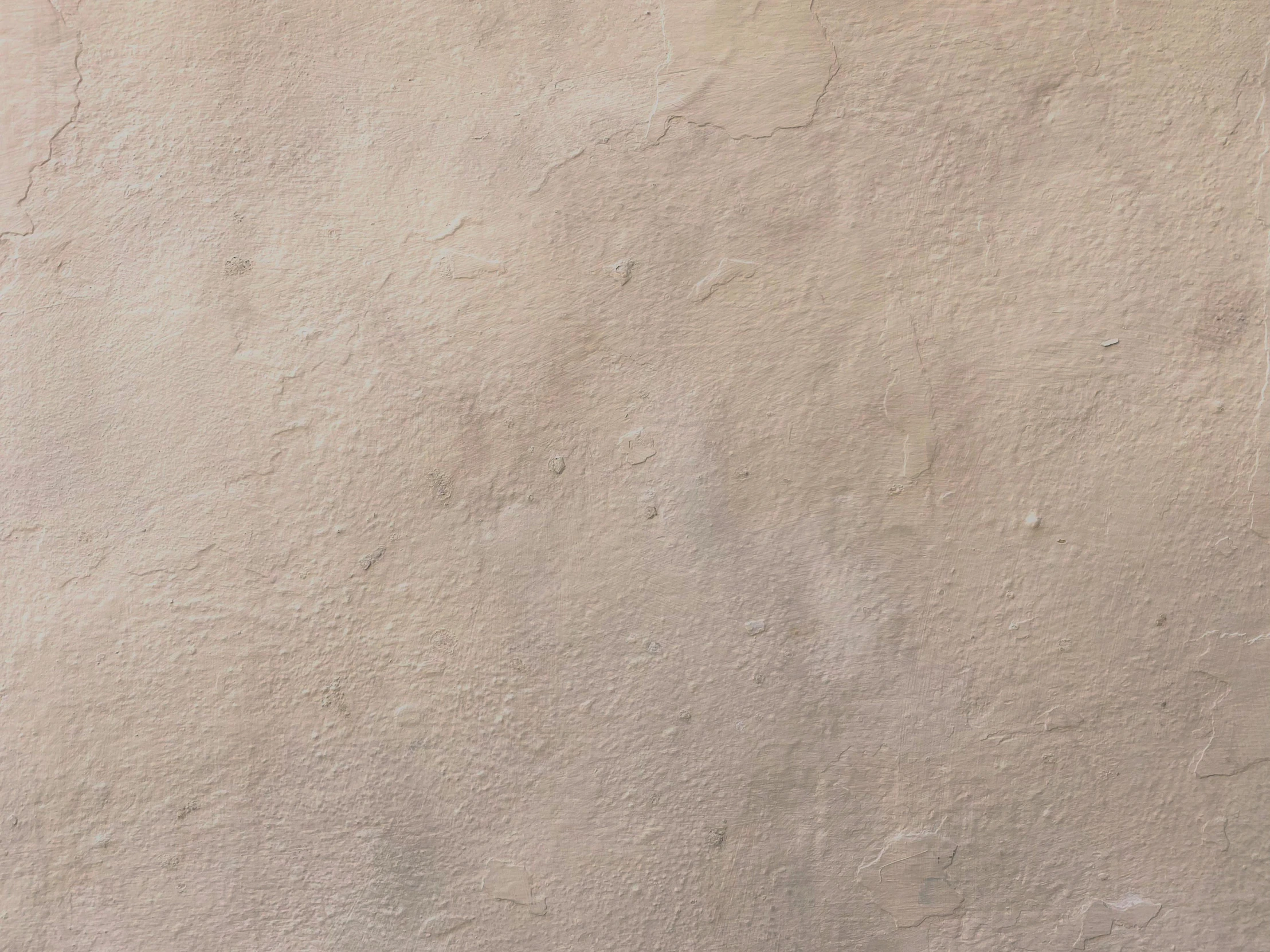 a small child is holding a tennis racket in front of a concrete wall