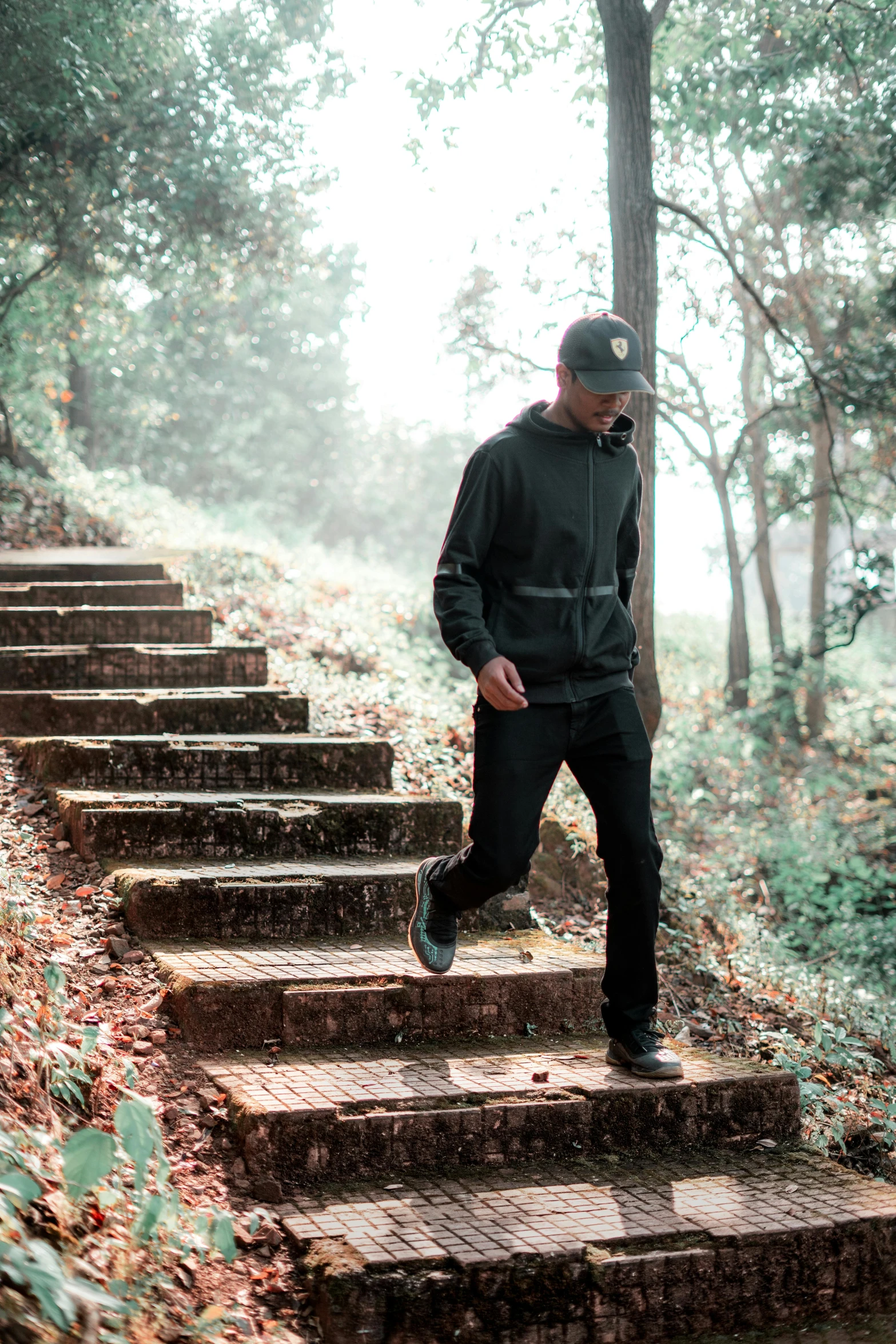 a person in sneakers and an oversize hoodie is standing at the top of stairs