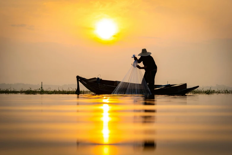 the person on a small boat is throwing water into the air