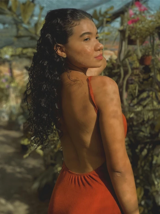 a woman standing in front of a group of plants