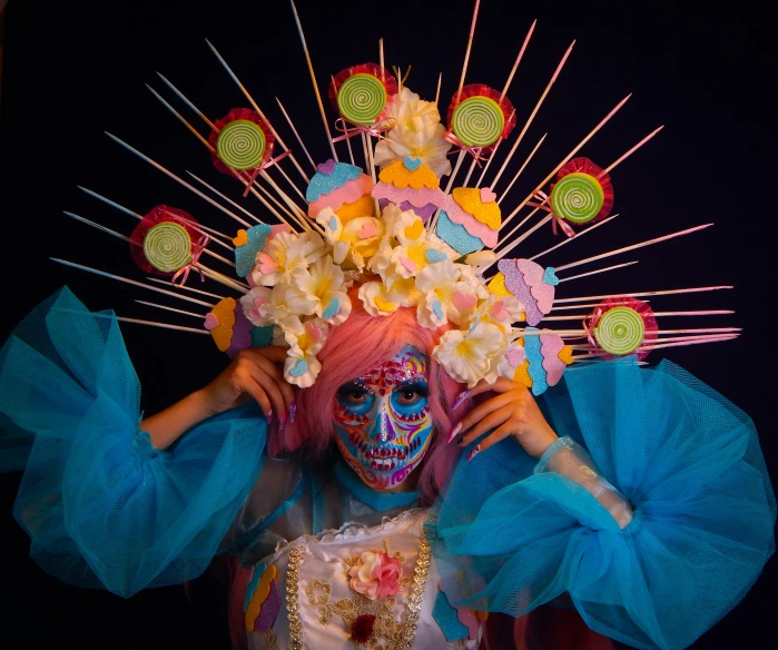 a woman with colorful makeup and makeup art posing for a picture