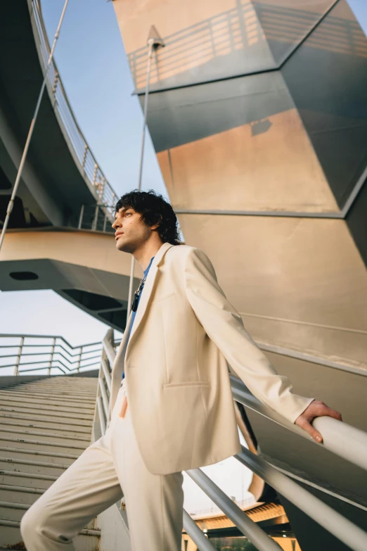 a person wearing a suit and leaning on a railing