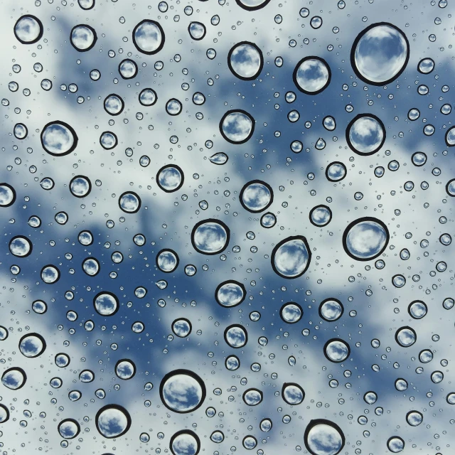 drops of water on a window showing the sky