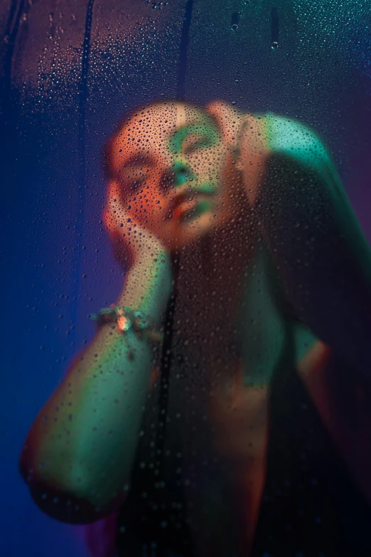 a woman in black underwear standing behind a rain covered window