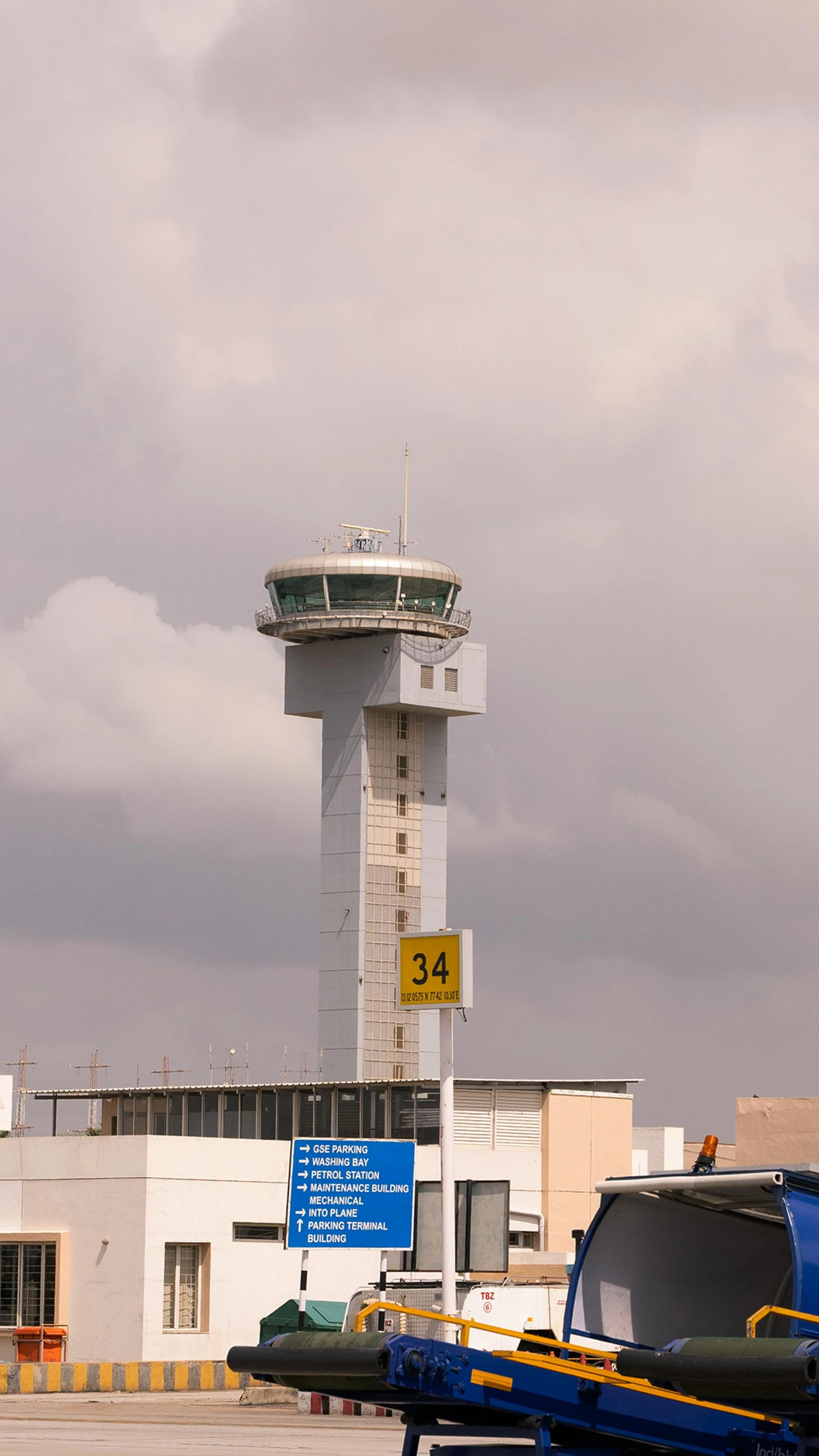 a control tower stands beside the airport runway