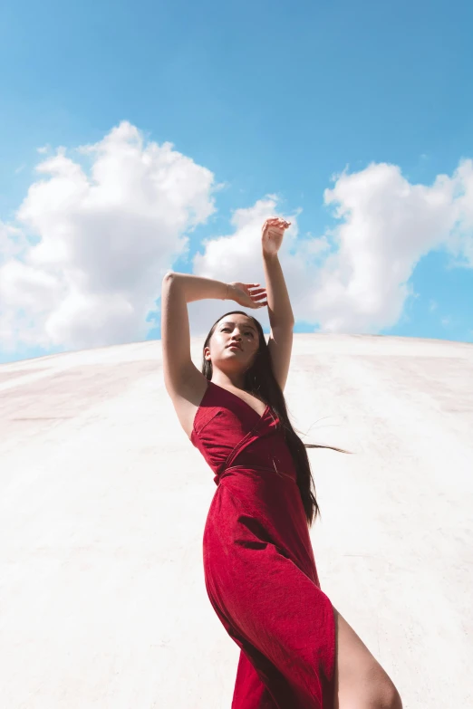 the woman is dancing in the sand in a very long dress