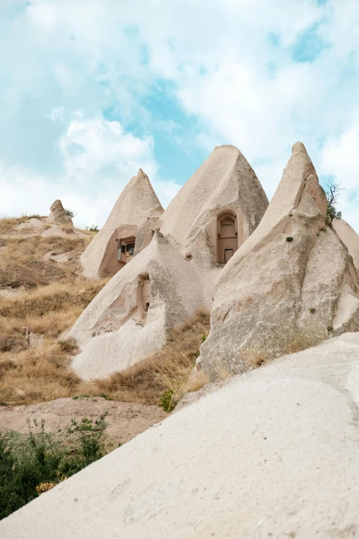 some very large rocks on a hill with a small house in them