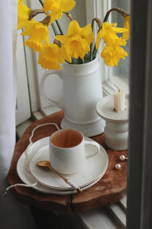 a plate with flowers on it next to a coffee cup