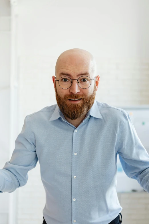 a bald man wearing glasses and a blue shirt