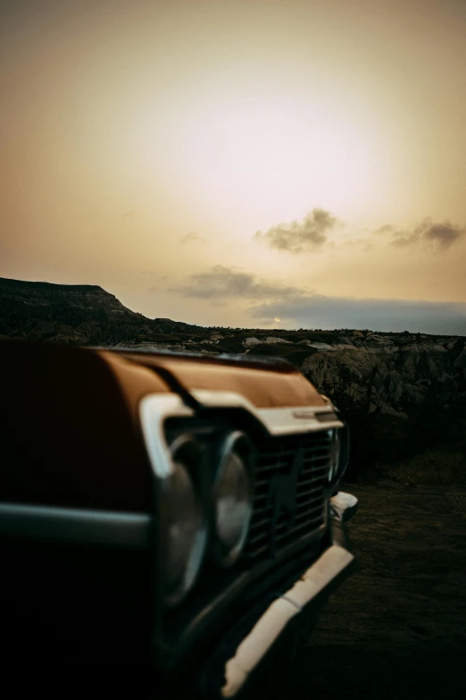 a desert sunset with an abandoned pickup truck