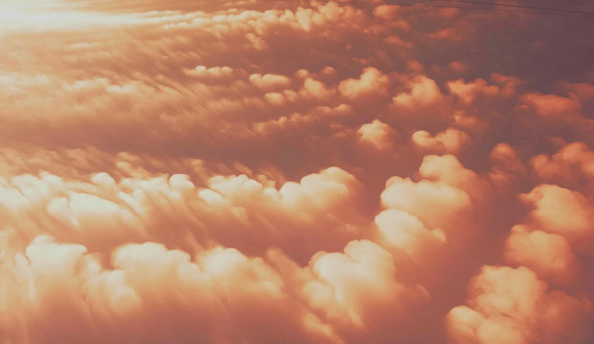 clouds are seen from an airplane wing