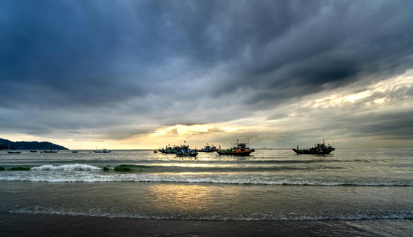 three boats floating in the ocean next to each other