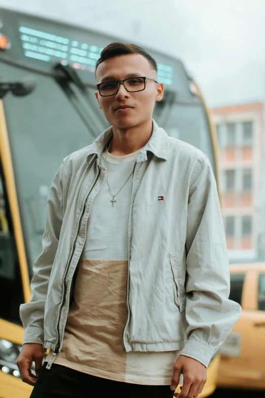 a young man standing next to a city bus