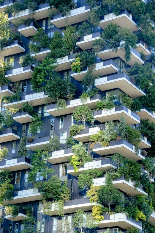 an apartment building with vertical trees growing on the side