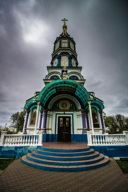 an ornate structure with blue steps leading to the door