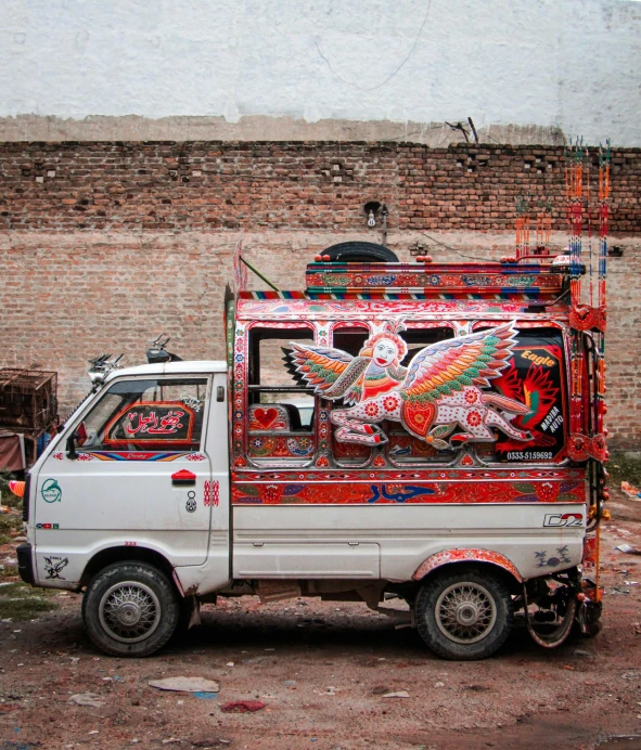 the truck with the dragon on it is parked near a brick wall